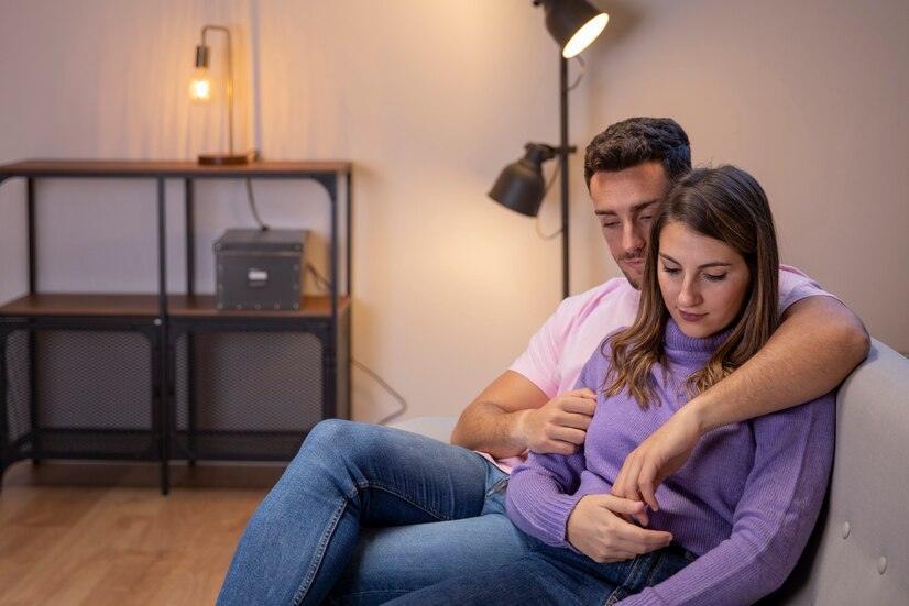 sad couple sitting on a couch