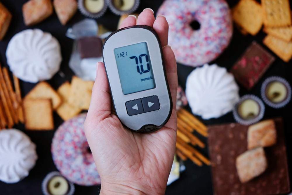 diabetes concept sweets unhealthy food with glucometer hand nutrition cause diabetic disease